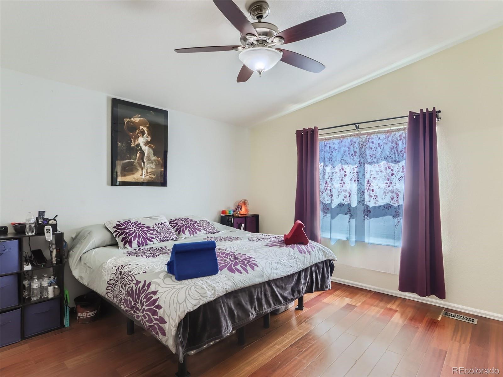 8080 Raspberry Drive Frederick, CO 80504 - Photo 11 of 29 a bedroom with a bed and wooden floor