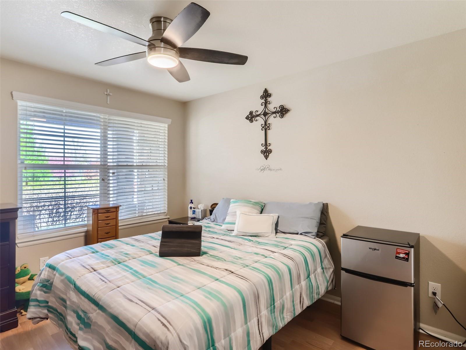 8080 Raspberry Drive Frederick, CO 80504 - Photo 15 of 29 a bedroom with a bed and wooden floor