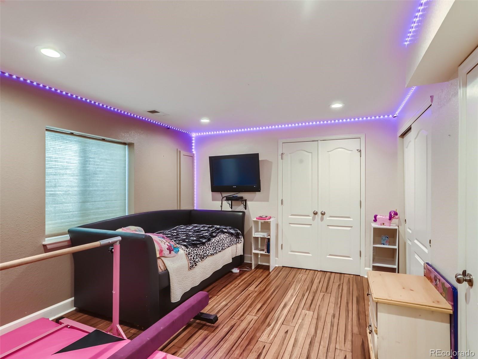 8080 Raspberry Drive Frederick, CO 80504 - Photo 19 of 29 a bedroom with a bed and flat screen tv