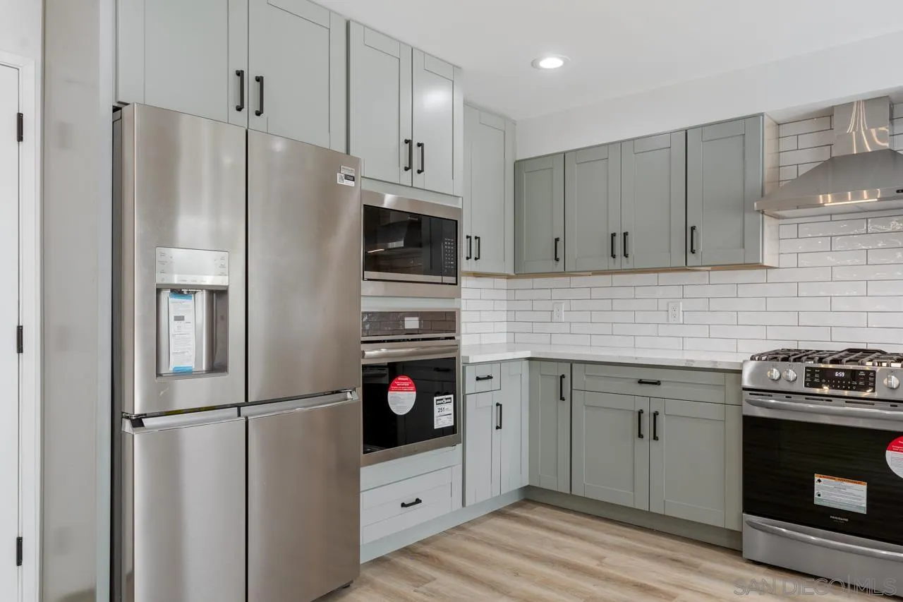 1706 Catalpa Road Carlsbad, CA 92011 - Photo 13 of 41 a kitchen with a refrigerator stove and white cabinets