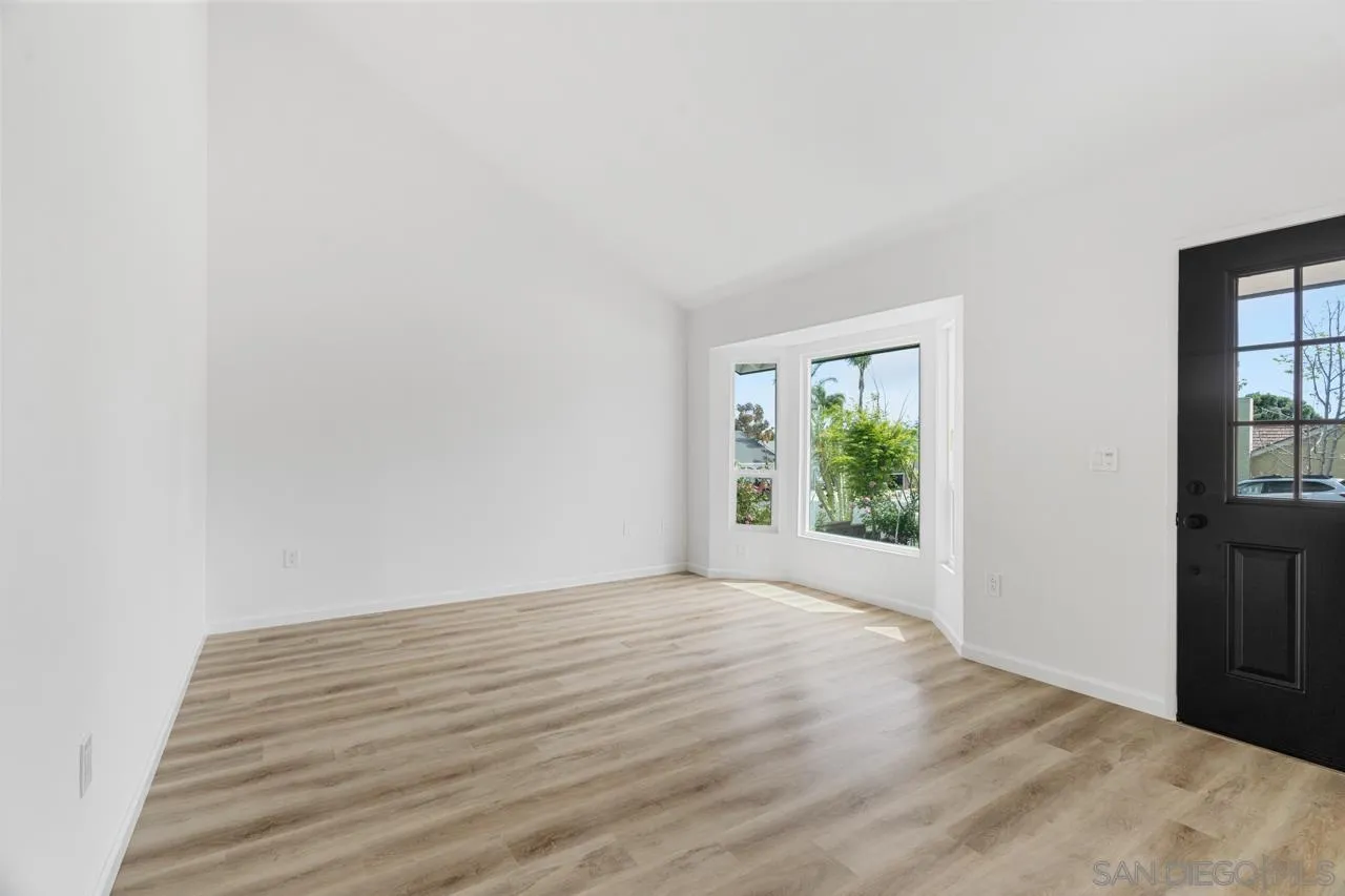 1706 Catalpa Road Carlsbad, CA 92011 - Photo 4 of 41 a view of an empty room with wooden floor and a window