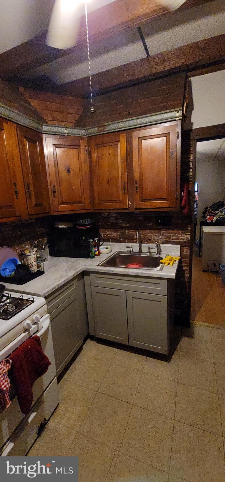 1357 North 10th Street Reading, PA 19604 - Photo 19 of 40 a kitchen with stainless steel appliances granite countertop a stove a sink and a microwave