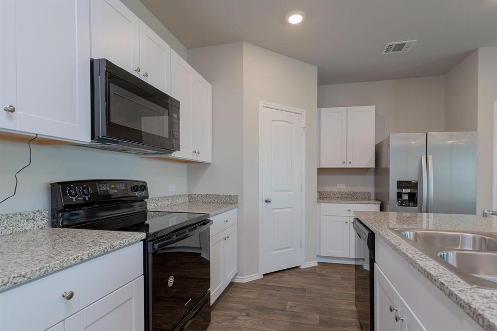 6009 Ronee Leah Drive Austin, TX 78724 - Photo 6 of 16 A well-appointed kitchen features ample counter space, contemporary appliances, and rich wood-look flooring.