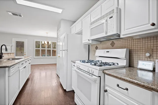 a kitchen with granite countertop a stove sink and cabinets