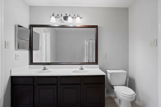 a bathroom with a toilet sink and mirror