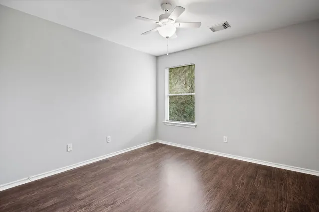 wooden floor in an empty room with a window