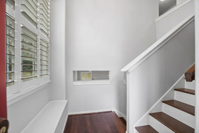 a view of a hallway with wooden floor and staircase