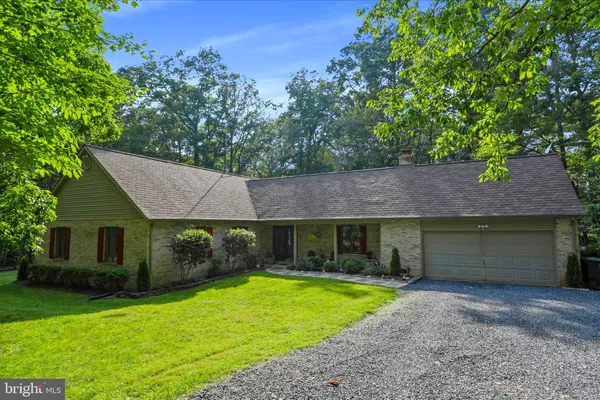 a view of a house with a yard and a large tree