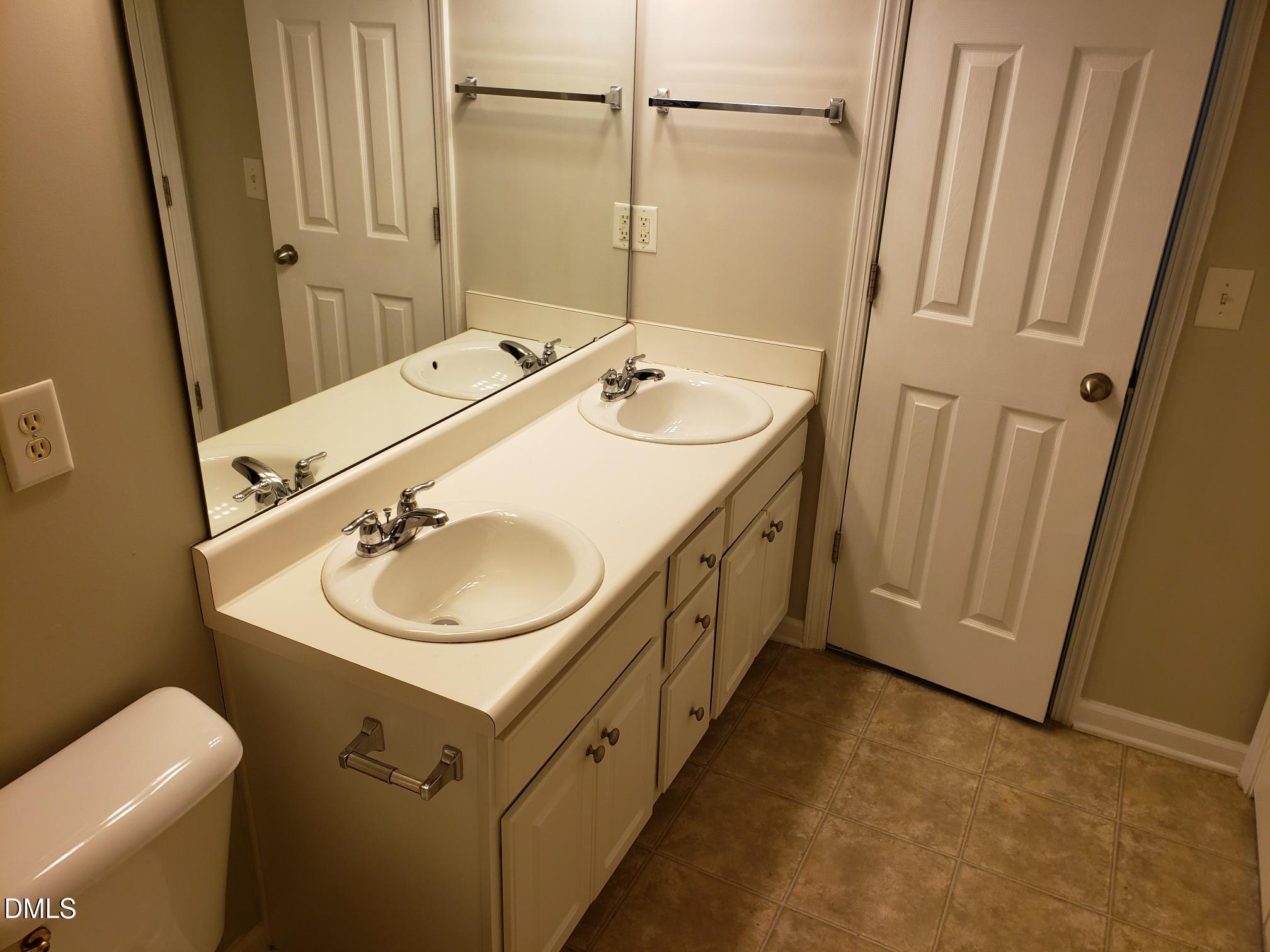 8212 Clasara Circle Raleigh, NC 27613 - Photo 6 of 20 a bathroom with a sink a toilet and mirror