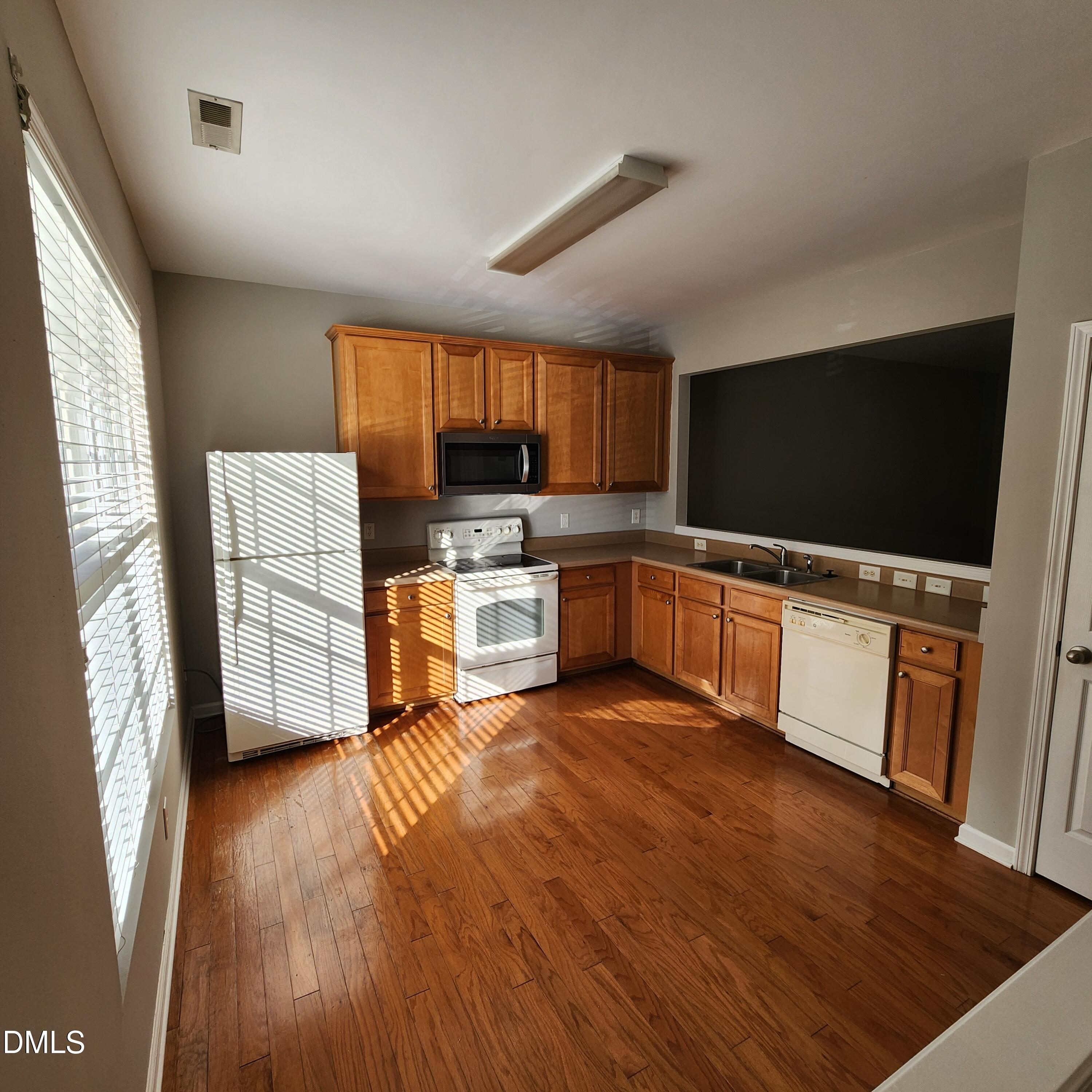 8212 Clasara Circle Raleigh, NC 27613 - Photo 8 of 20 a kitchen with stainless steel appliances a stove top oven a sink a microwave a dining table and chairs