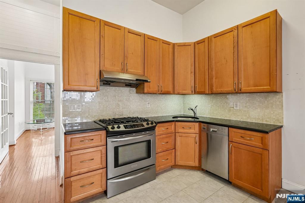 90 A Hackensack Plank Road Weehawken, NJ 07086 - Photo 15 of 40 a kitchen with granite countertop cabinets stainless steel appliances and wooden floor