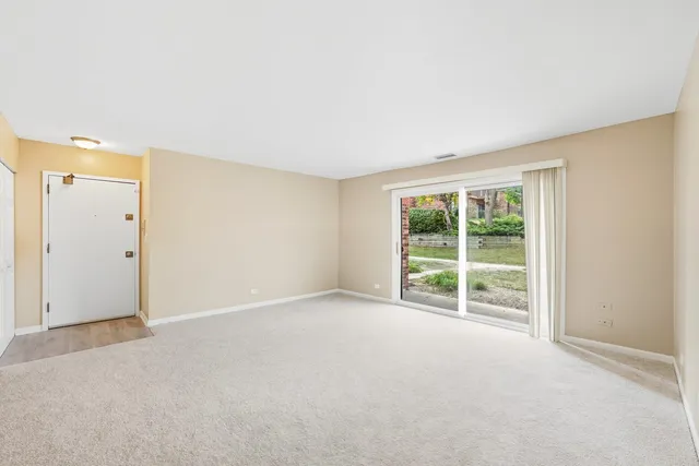an empty room with large window and front door