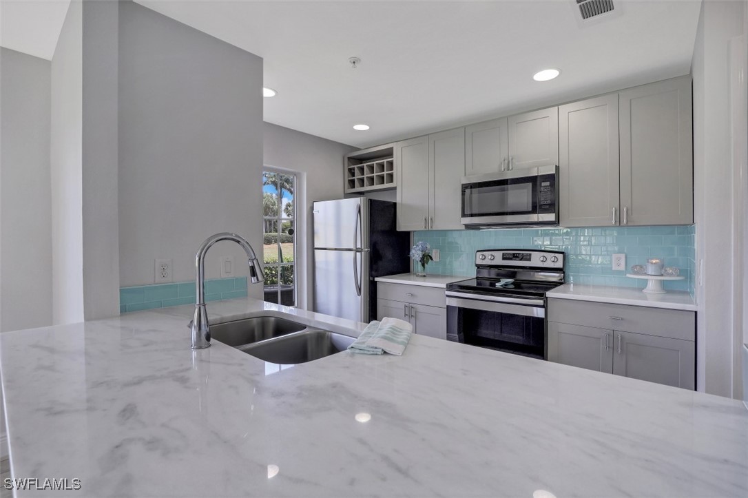 a kitchen with stainless steel appliances granite countertop a refrigerator and a sink