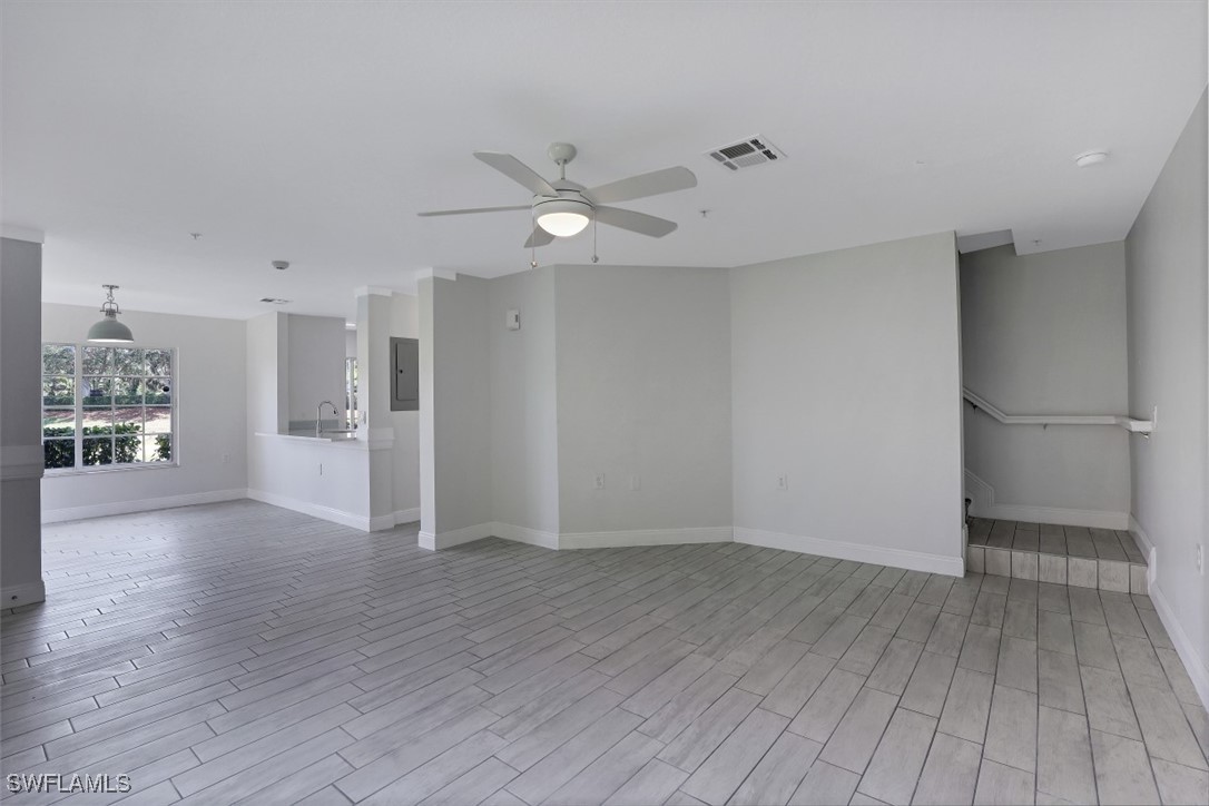 9465 Ivy Brook Run, Unit 901 Fort Myers, FL 33913 - Photo 11 of 24 a view of an empty room with wooden floor and a kitchen