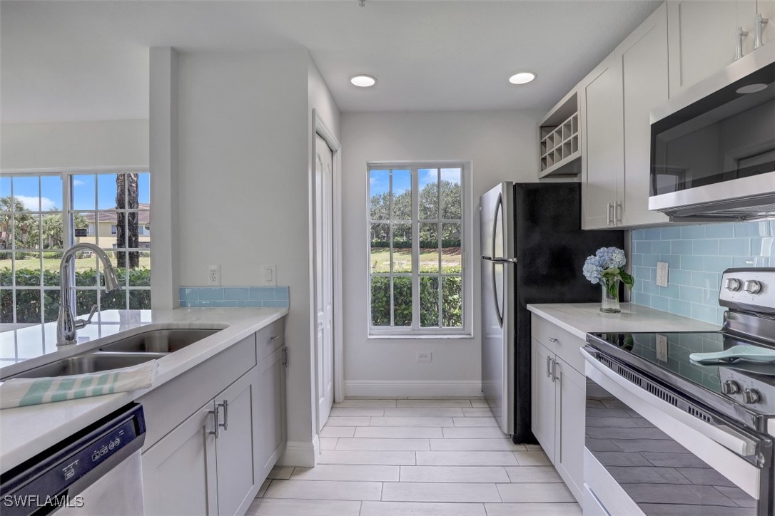 9465 Ivy Brook Run, Unit 901 Fort Myers, FL 33913 - Photo 3 of 24 a kitchen with stainless steel appliances granite countertop a sink a stove and a refrigerator