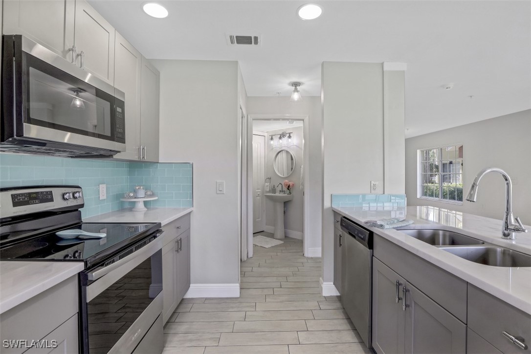 9465 Ivy Brook Run, Unit 901 Fort Myers, FL 33913 - Photo 5 of 24 a kitchen with stainless steel appliances granite countertop a sink stove and refrigerator