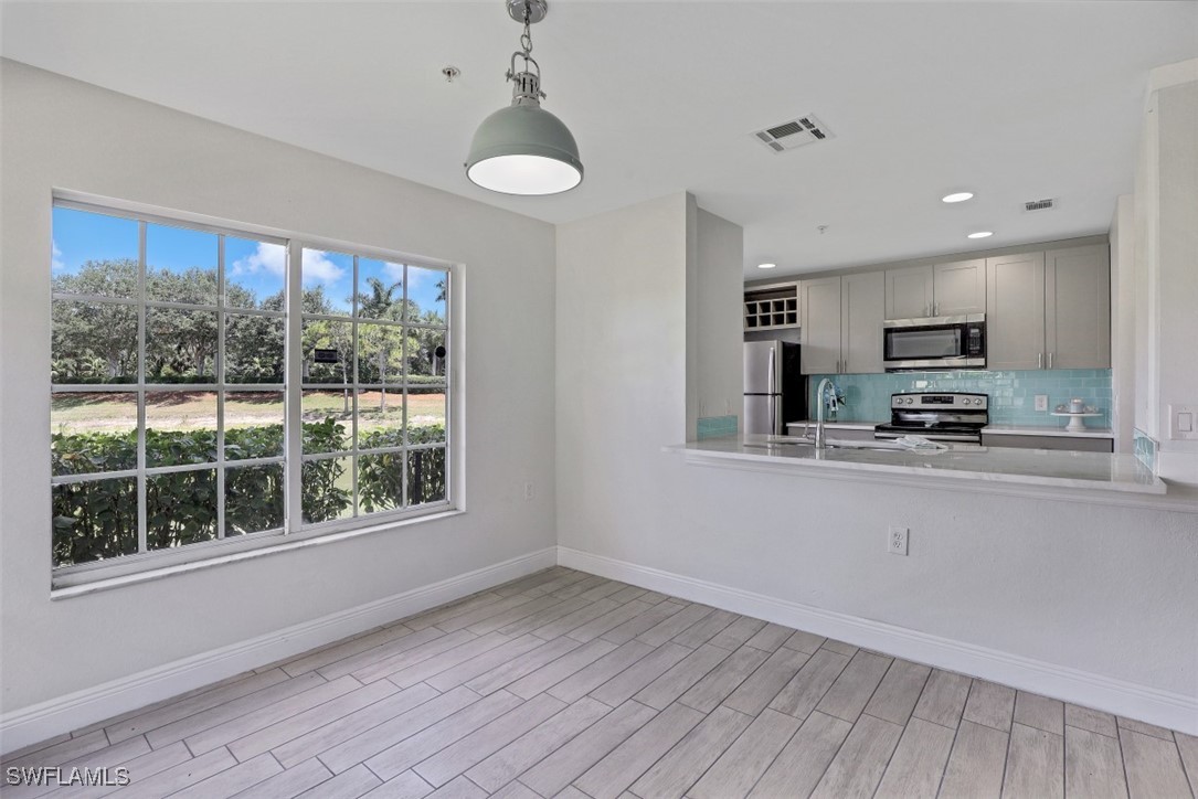 9465 Ivy Brook Run, Unit 901 Fort Myers, FL 33913 - Photo 8 of 24 a kitchen with stainless steel appliances granite countertop a stove a sink and a refrigerator