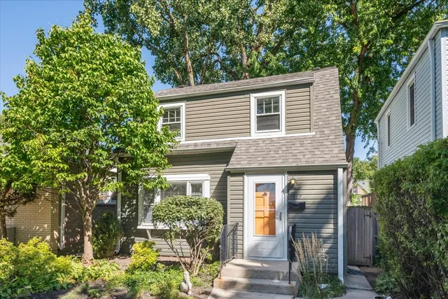 a front view of a house with a yard and potted plants
