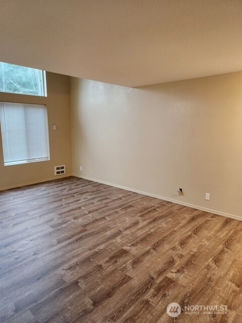 12303 Alexander Road Everett, WA 98204 - Photo 14 of 19 a view of an empty room with wooden floor and a window