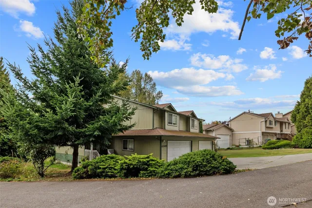 a view of a house with backyard and trees