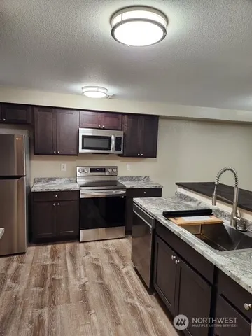 a kitchen with stainless steel appliances granite countertop a sink stove and refrigerator