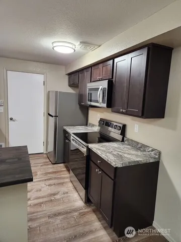 a kitchen with stainless steel appliances granite countertop a sink and a stove top oven