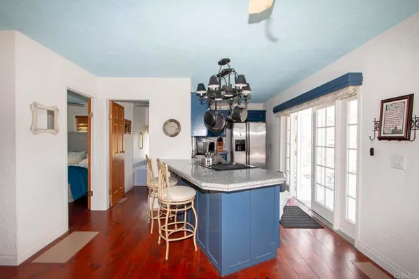a dining room with furniture a chandelier and wooden floor