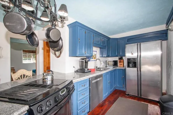 a kitchen with stainless steel appliances granite countertop a stove a sink dishwasher and cabinets with wooden floor