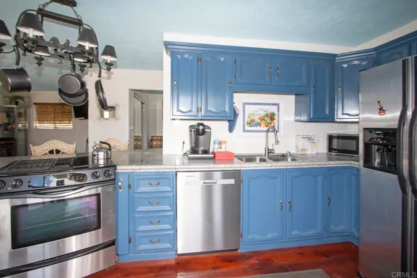 a kitchen with granite countertop wooden cabinets and stainless steel appliances