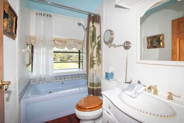 a bathroom with a granite countertop sink mirror toilet and bathtub