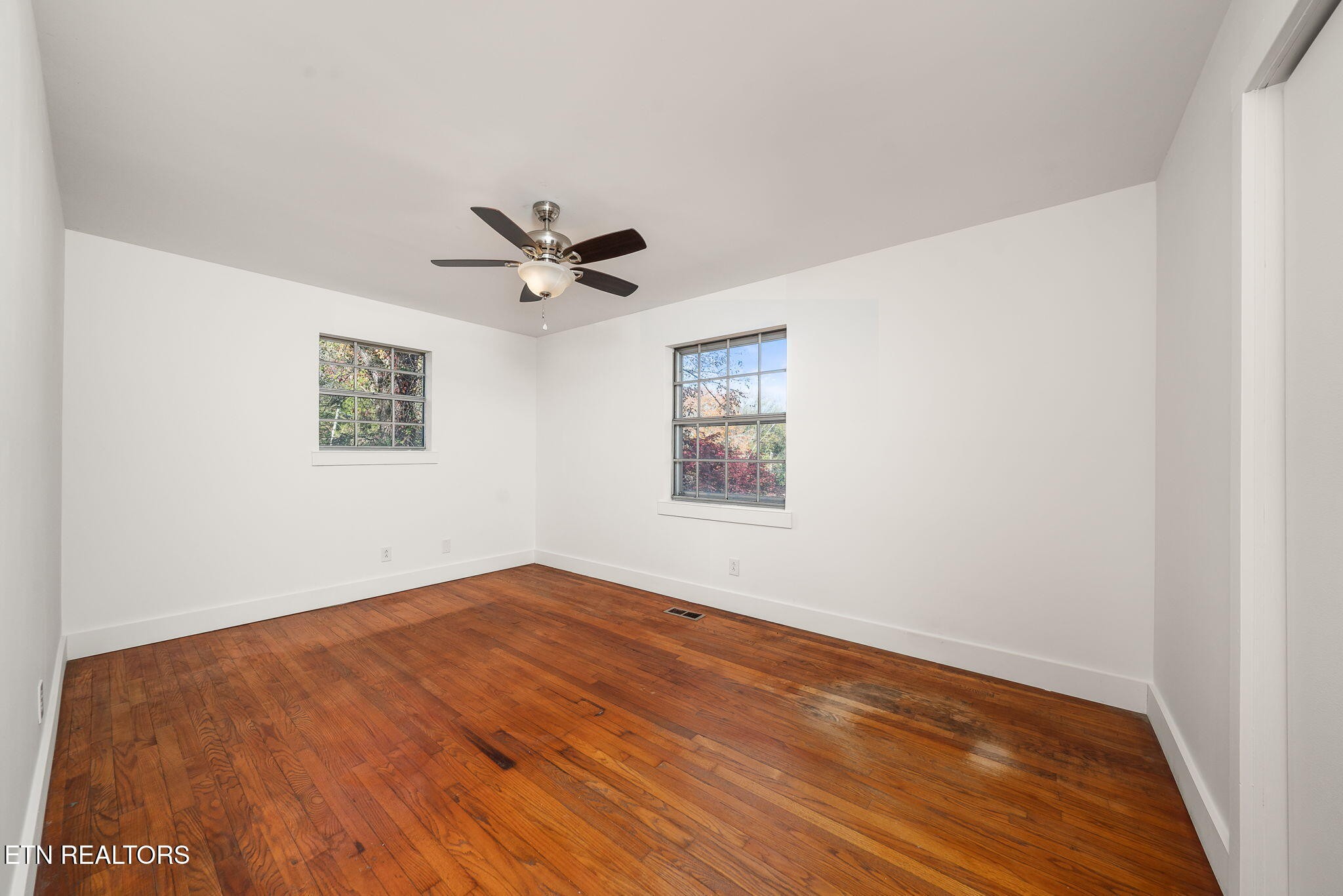 287 Watson Avenue Spring City, TN 37381 - Photo 15 of 24 a view of a big room with wooden floor and a ceiling fan