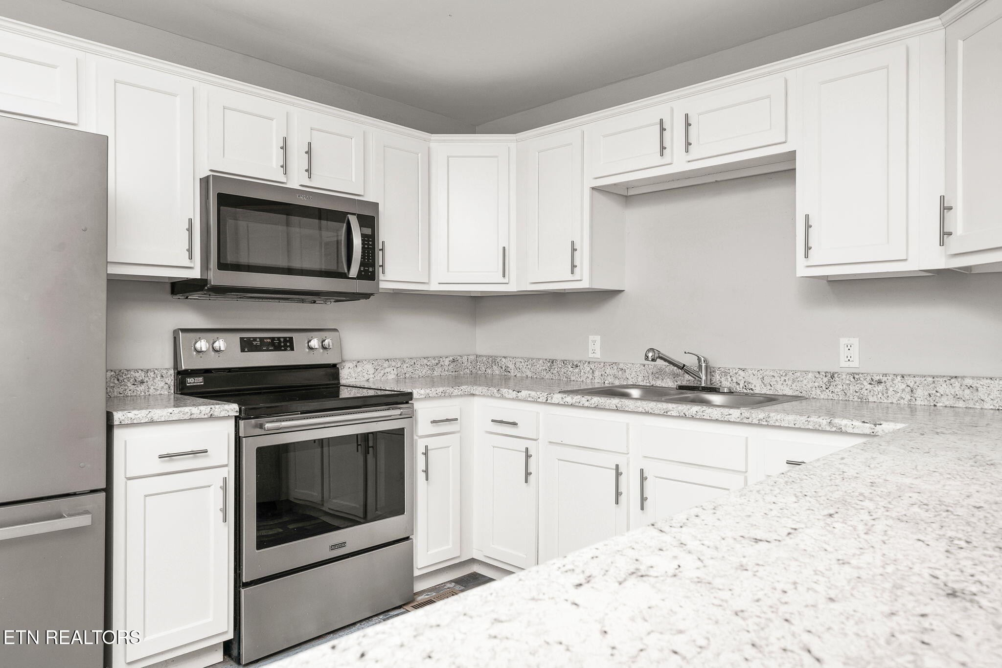287 Watson Avenue Spring City, TN 37381 - Photo 6 of 24 a kitchen with granite countertop white cabinets sink and stainless steel appliances