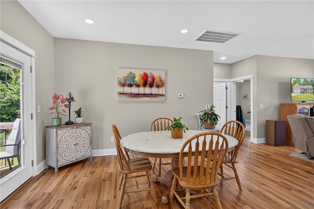 405 Pawnee Drive Walhalla, SC 29691 - Photo 3 of 36 Hardwood floors and ample recessed lighting elevate this inviting dining space with seamless outdoor access.