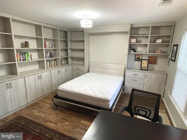 a room with a bed and a book shelf