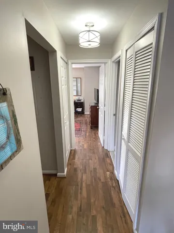 a view of a hallway with wooden floor and staircase