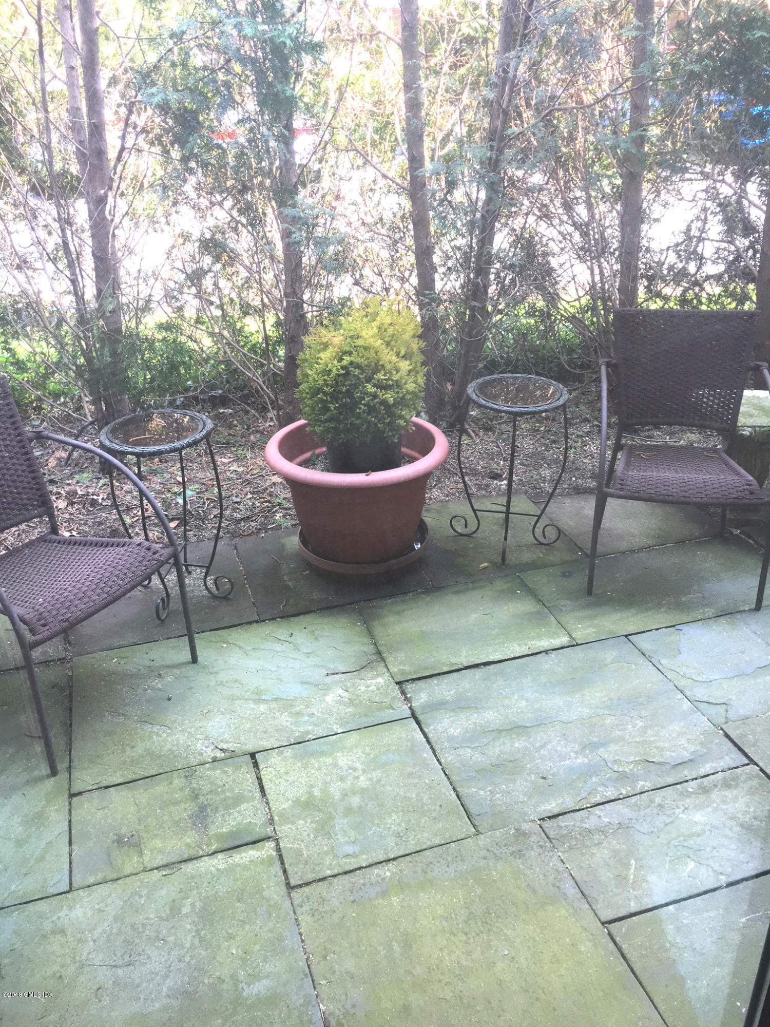 140 Field Point Road, Unit 2 Greenwich, CT 06830 - Photo 10 of 14 a view of a backyard with table and chairs potted plants and tree