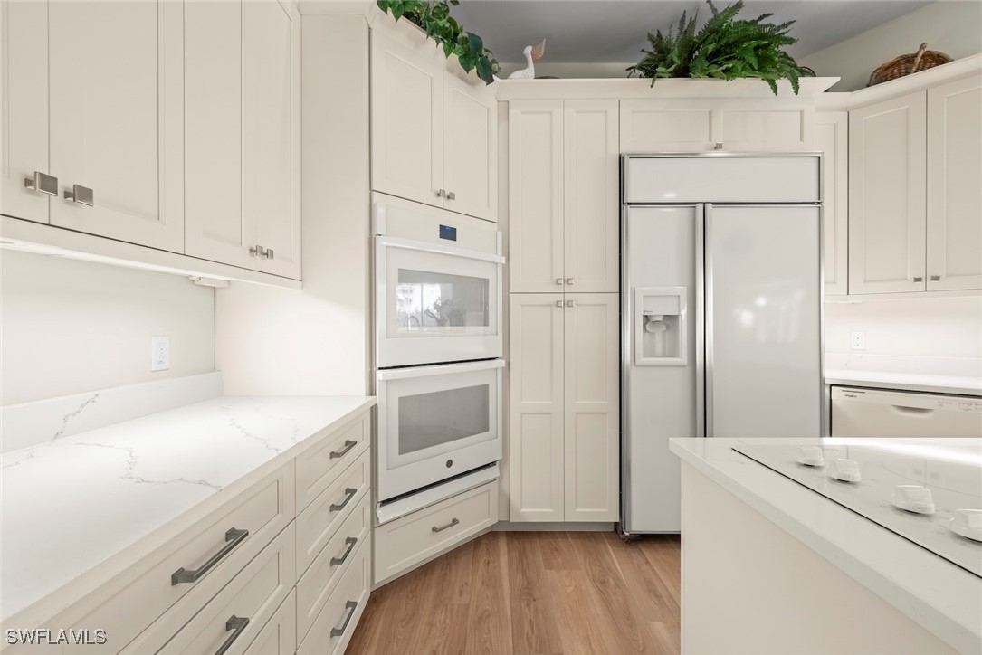 2337 Wulfert Road Sanibel, FL 33957 - Photo 11 of 45 a kitchen with white cabinets and white appliances