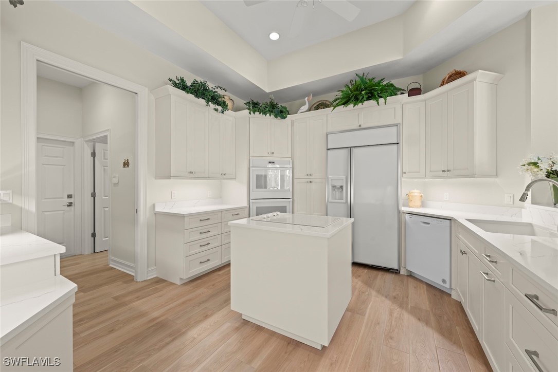 2337 Wulfert Road Sanibel, FL 33957 - Photo 10 of 45 a kitchen with white cabinets and white appliances