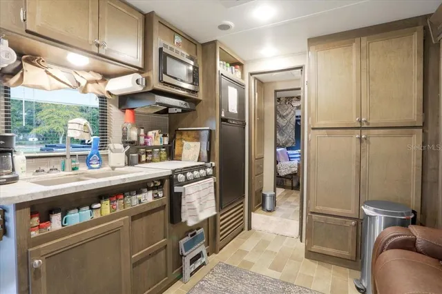 a kitchen with stainless steel appliances granite countertop a refrigerator and a stove