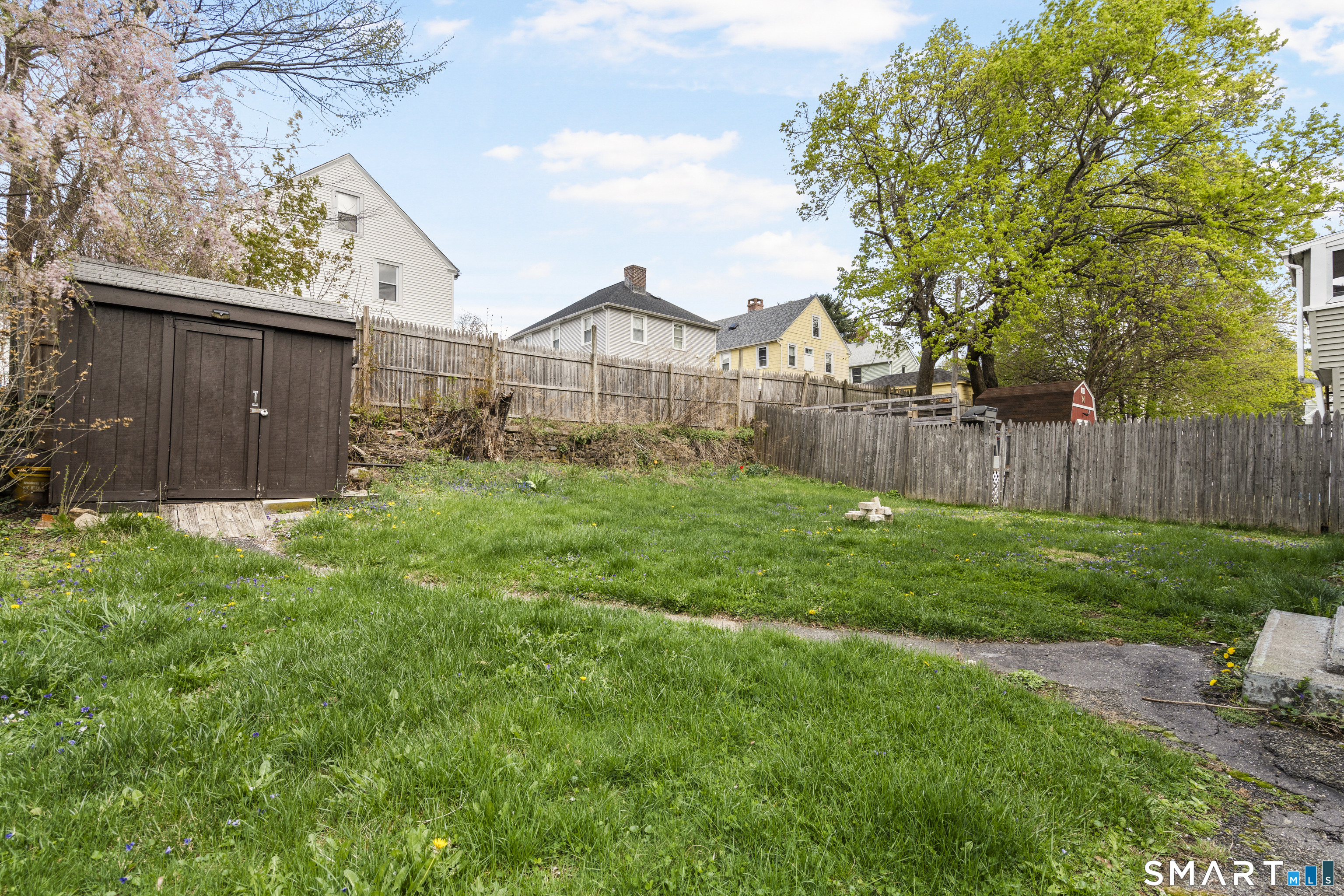 88 North Pond Street Bristol, CT 06010 - Photo 4 of 32 a view of a yard with a large tree and a wooden fence