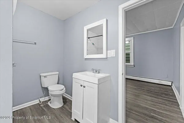 a bathroom with a toilet a sink and mirror