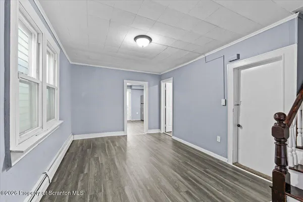 a view of a room with wooden floor and a window