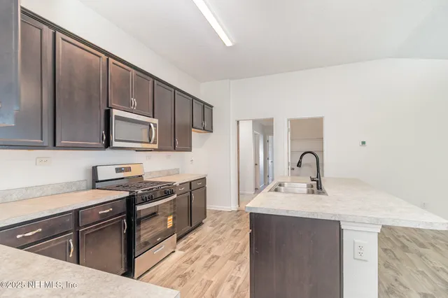 a kitchen with stainless steel appliances granite countertop a sink stove and cabinets