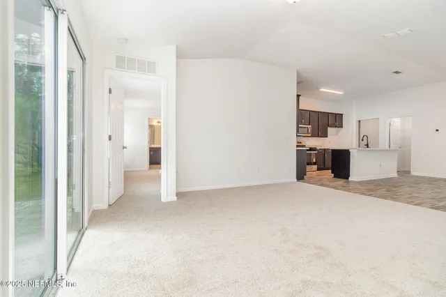 a view of a kitchen with a refrigerator and a sink