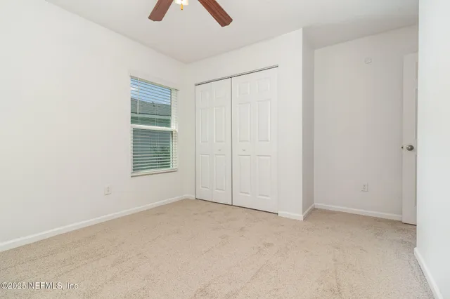 an empty room with chandelier fan