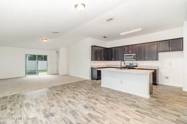 a view of kitchen with sink microwave and refrigerator