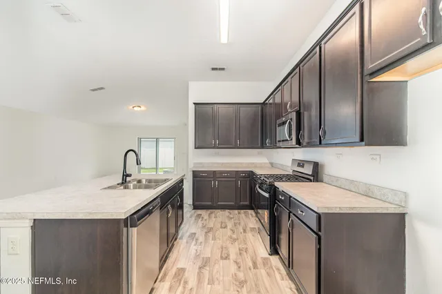 a kitchen with a sink stove and cabinets