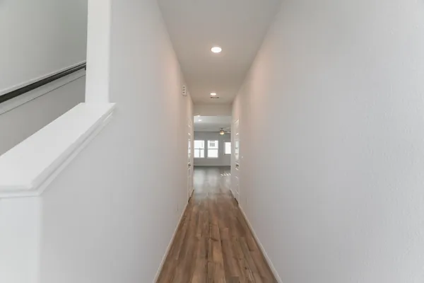a view of a hallway with wooden floor
