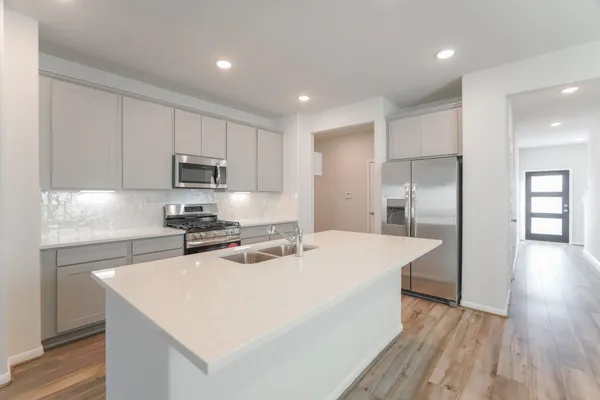 a kitchen with a appliances a sink and a refrigerator