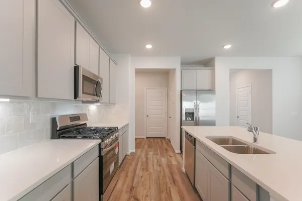 a kitchen with a sink appliances cabinets and a counter top space